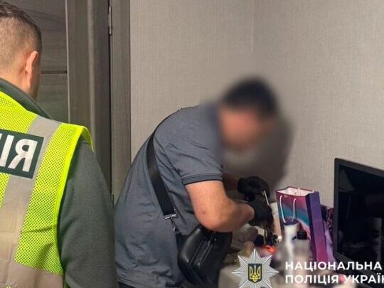 Співробітник поліції проводить обшук у помешканні підозрюваного.