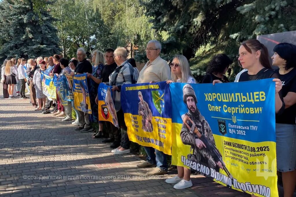 Люди з прапорами із інформацією про воїнів