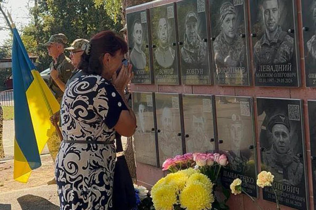 жінка біля портретів