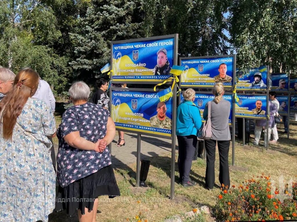 Люди біля портретів