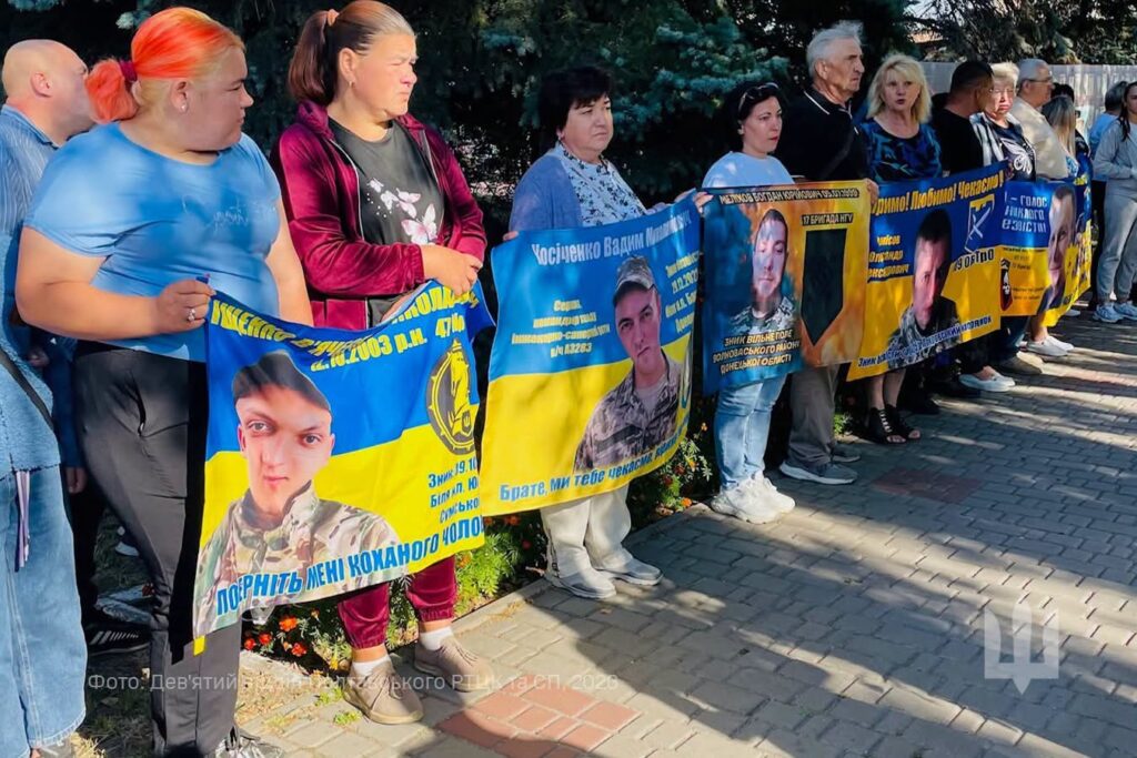 Люди з прапорами із інформацією про воїнів