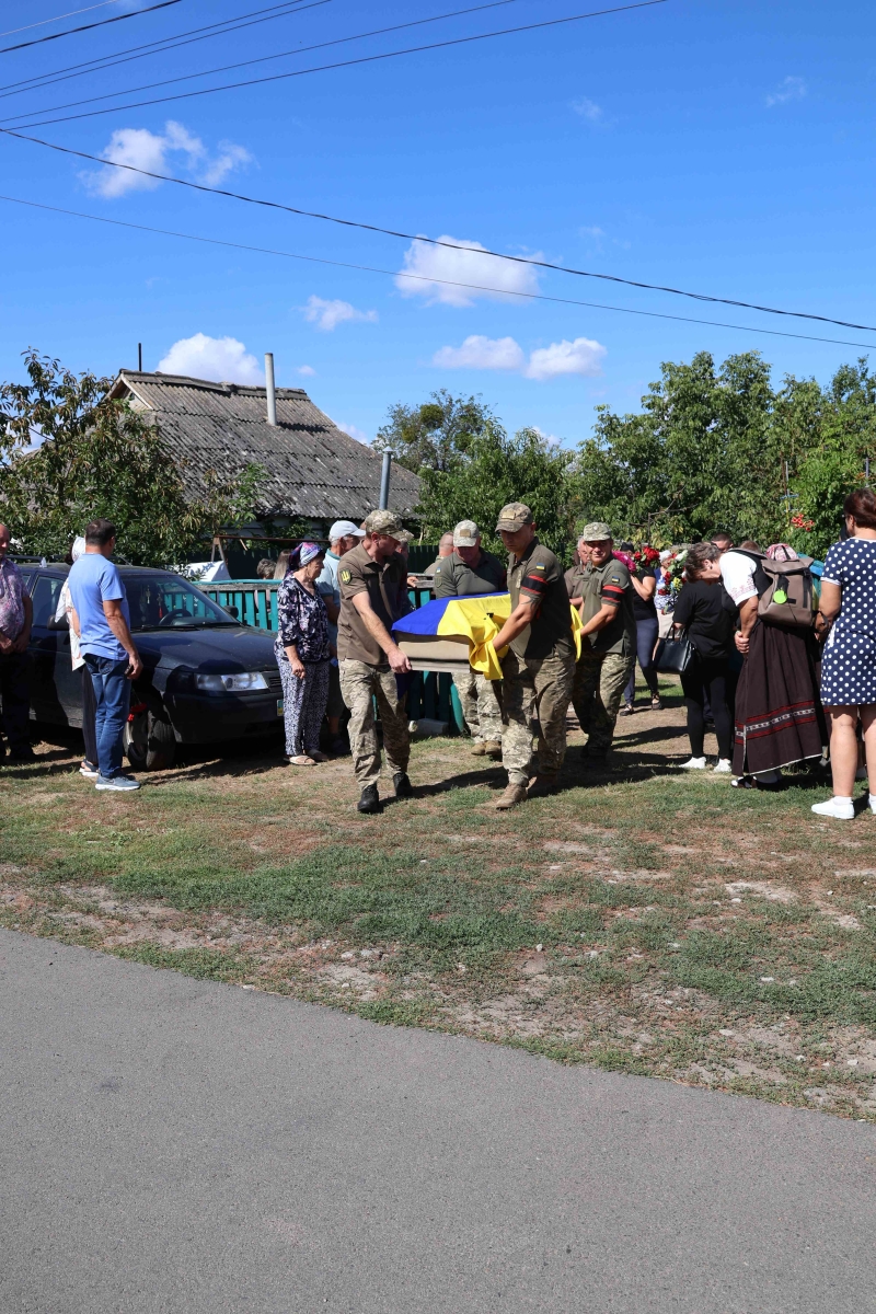 Військовики виносять труну з подвір'я біля хати, де проживав Максим Кривцун