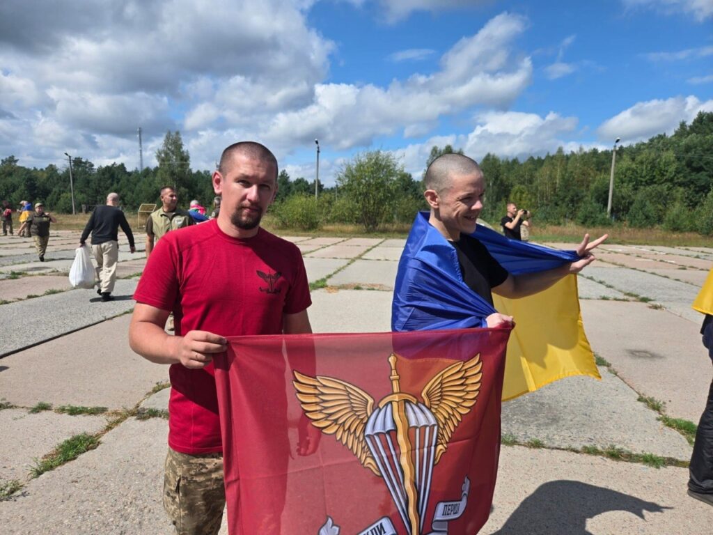 Два військовослужбовця з прапором своєї бригади