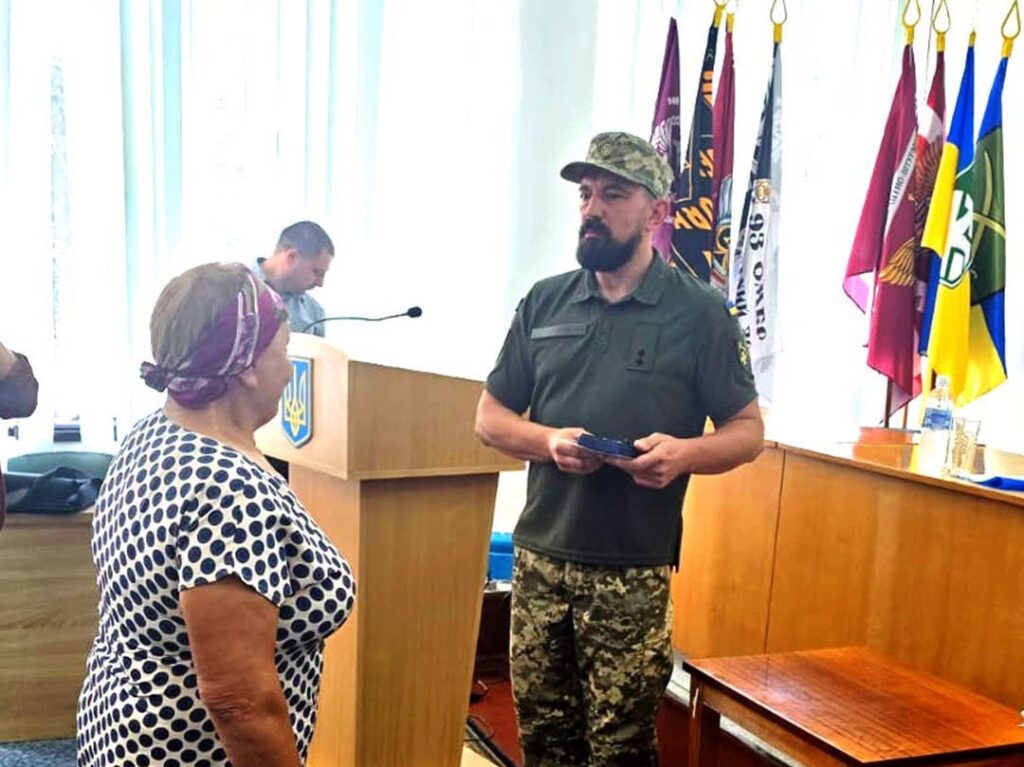 Представник ТЦК передає нагороду матері полеглого воїна