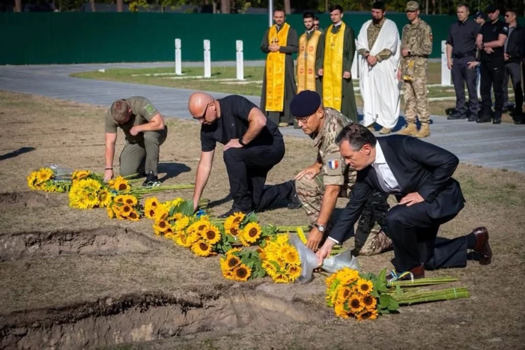 Люди кладуть квіти до могил