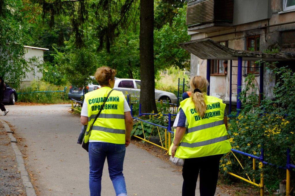 двоє сооціальних працівниць ідуть біля будинку