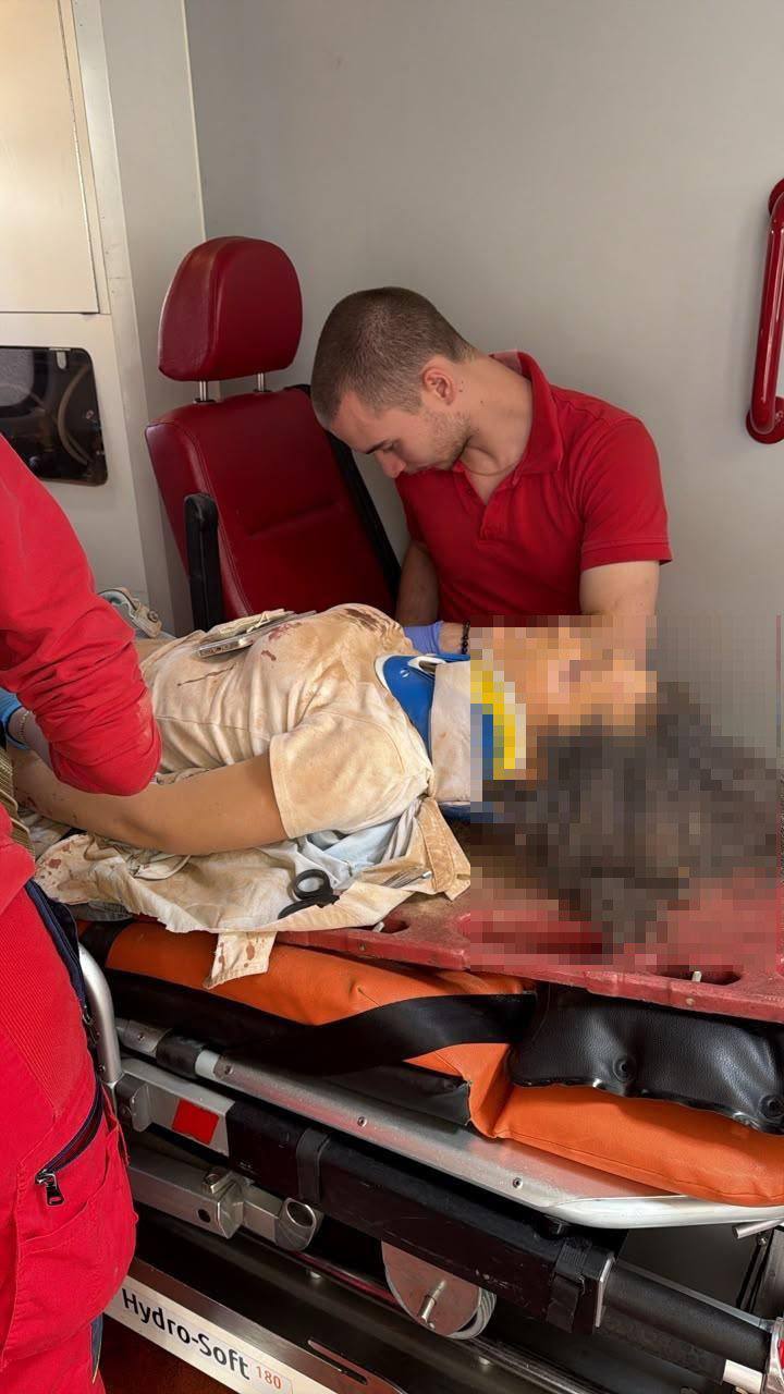 два медика надають допомогу жінці, яка лежить на каталці