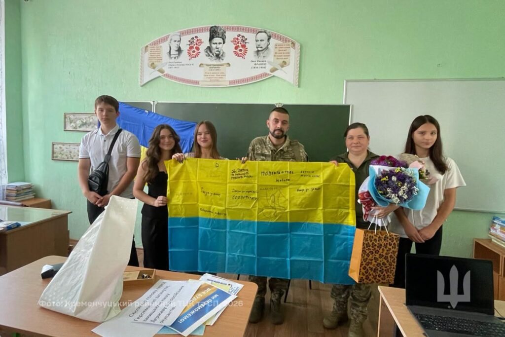 спільне фото військовиків та дітей із прапором
