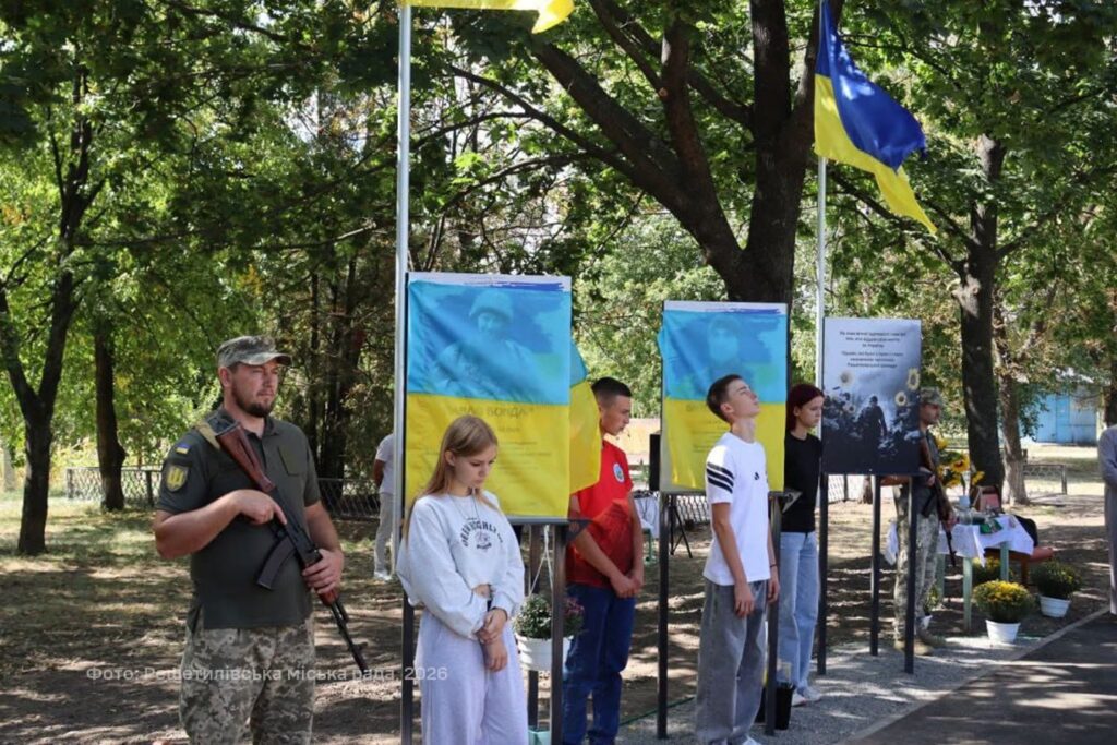 почесна варта з військовослужбовців і молоді біля портретів полеглих воїнів