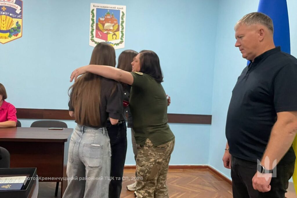 військовослужбовиця обіймає рідних нагородженого воїна