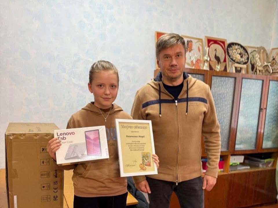 Олександр Біленький із переможницею торішнього конкурсу, яка тримає сертифікат і подарунок