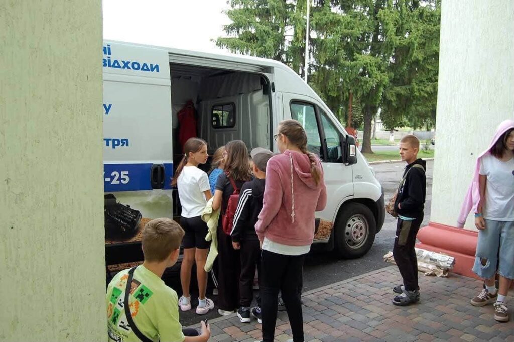 діти йдуть до відчинених дверцях екобусу