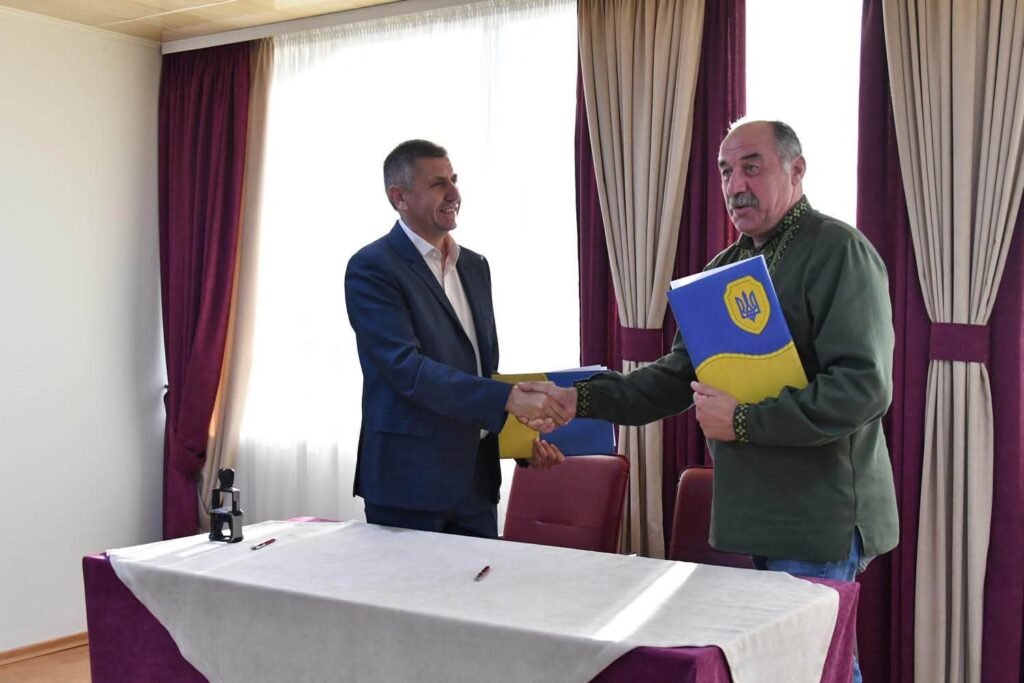 голови громад після підписання меморандуму потискають один одному руки
