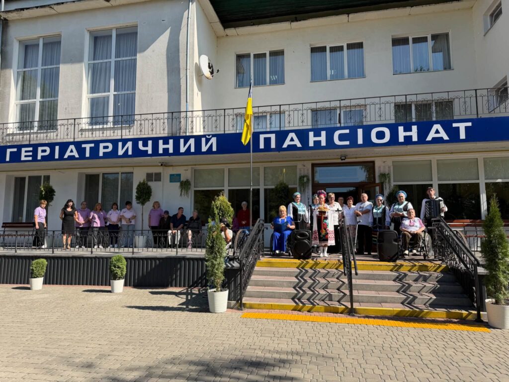 фасад геріатричного пансіонату і люди на ганку
