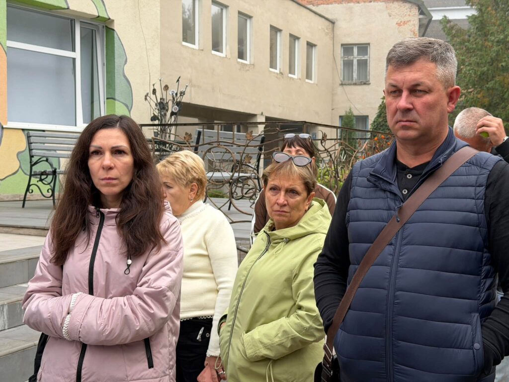 Люди біля двоповерхової будівлі