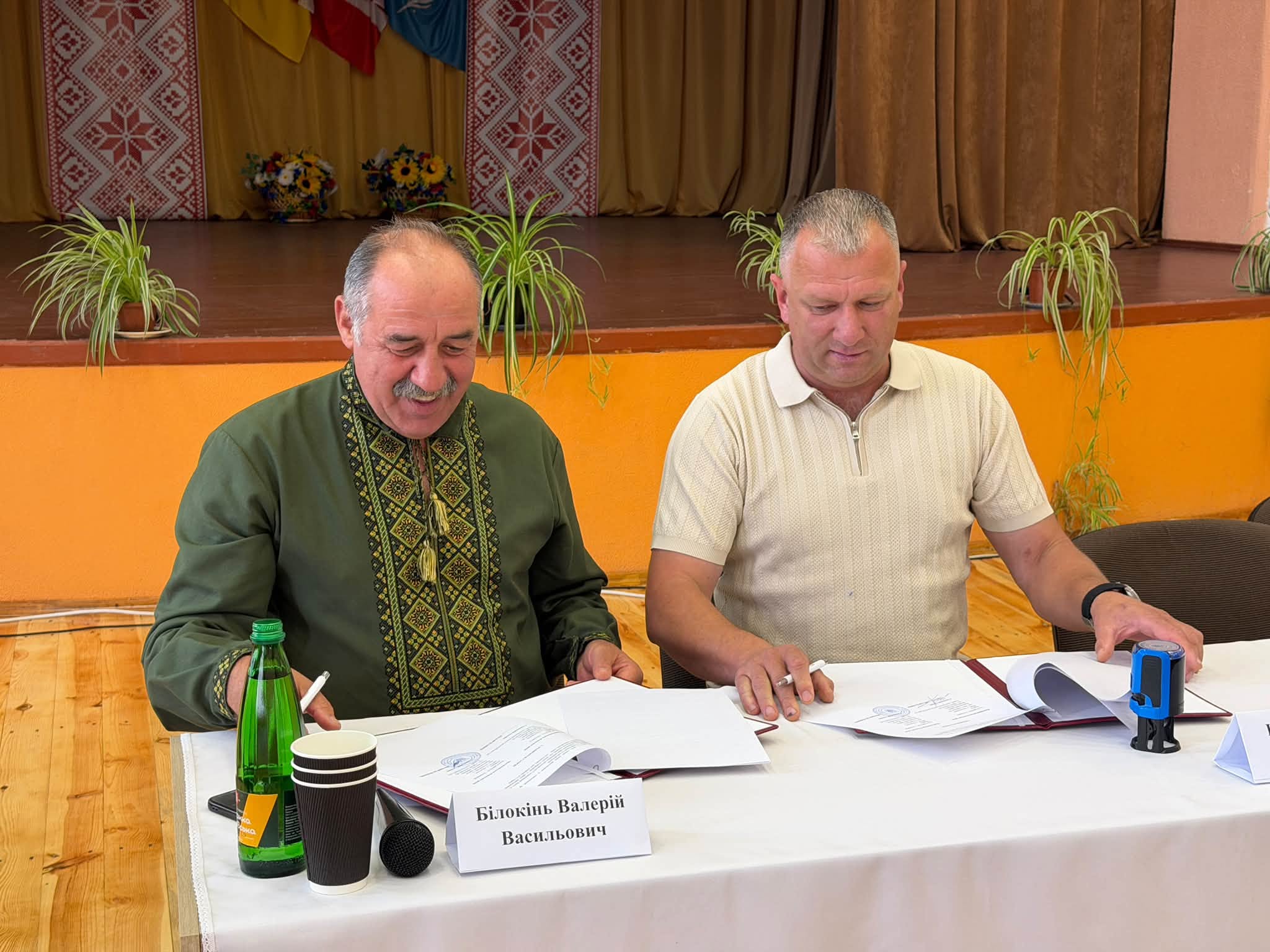Голови двох громад підписують за столом меморандум про співпрацю