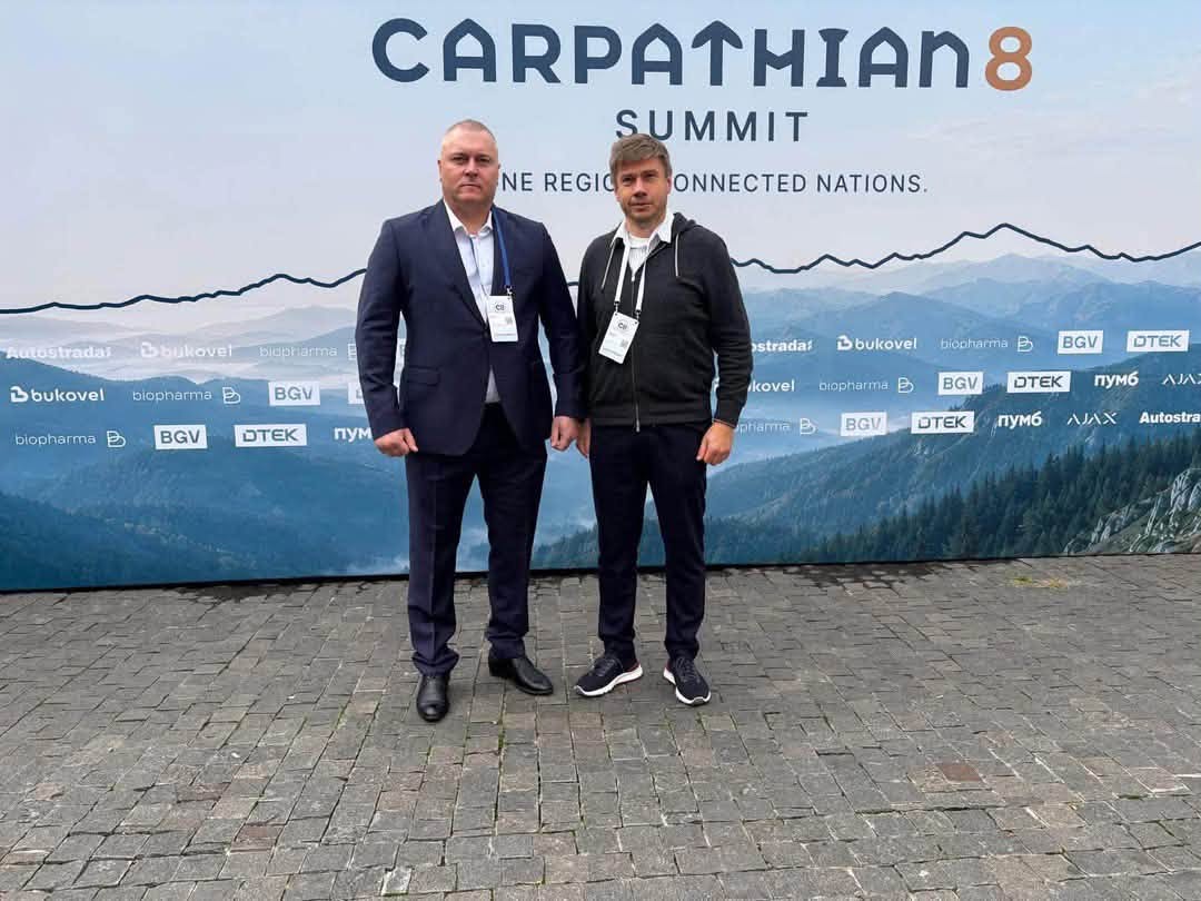 Віталій Дяківнич та Олександр Біленький на тлі банера форума Карпатська вісімка