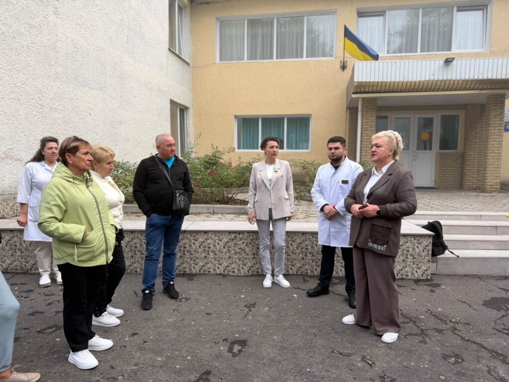 Люди перед двоповерховоою будівлею