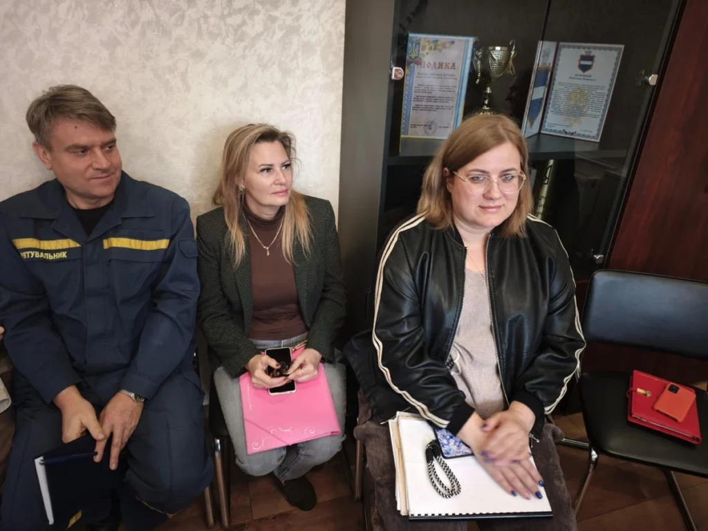 люди сидять на стільцях у кабінеті під стіною