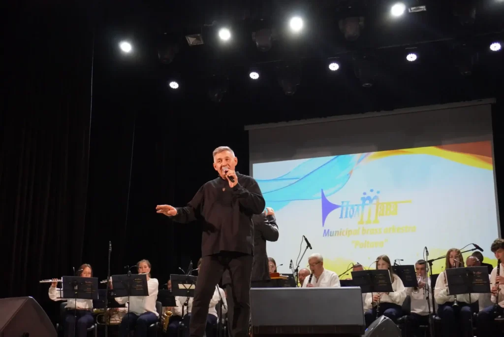 Геннадій Туксішвілі співає на сцені в супроводі оркестру