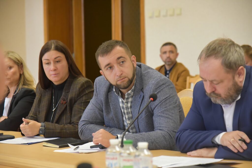доповідачі за столом у залі засідань