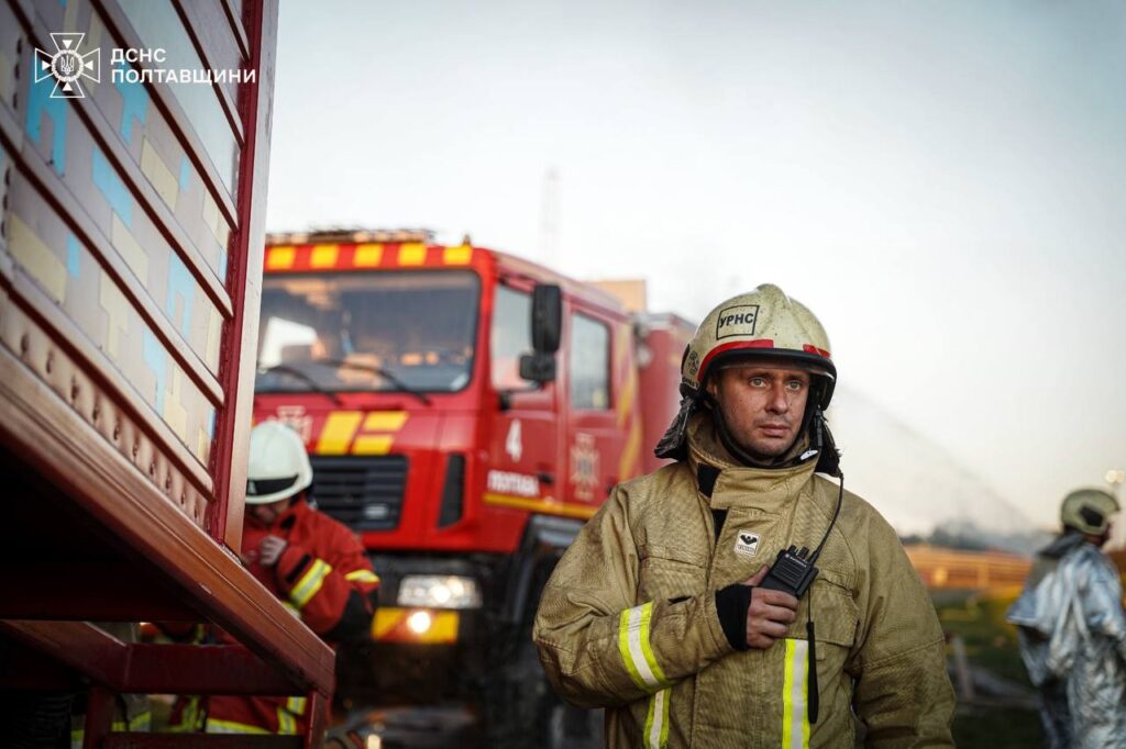 Рятувальник з рацією біля пожежної машини