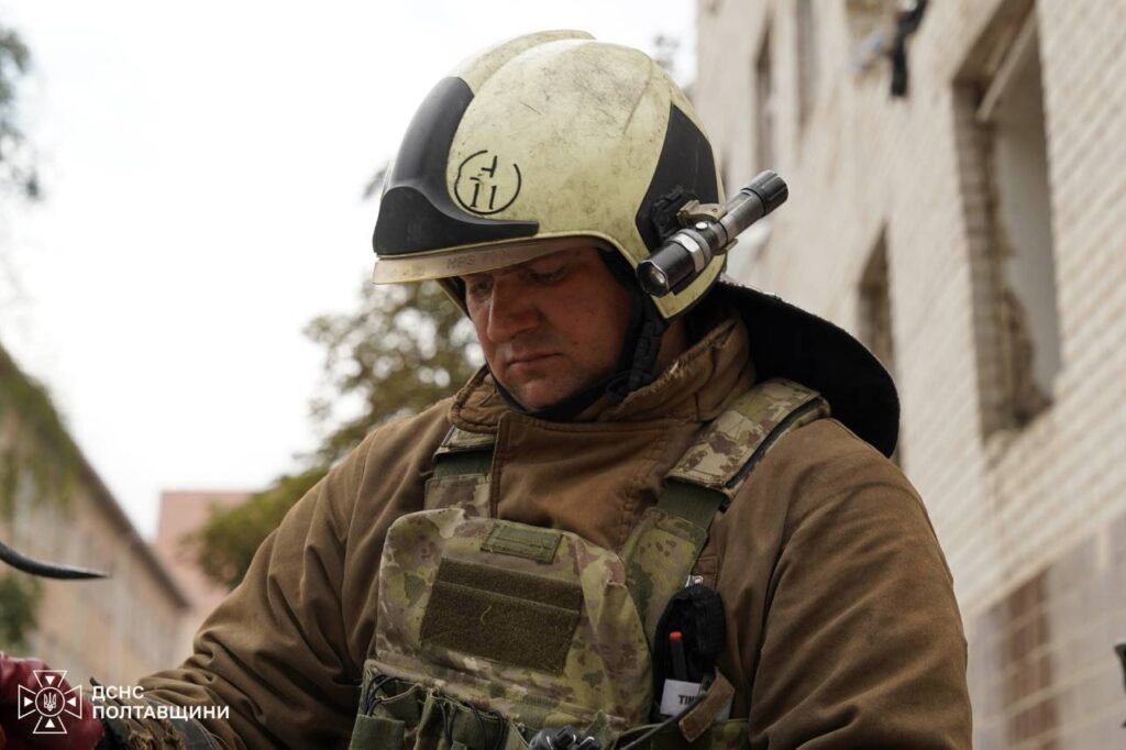 Рятувальник біля сірої цегляної будівлі
