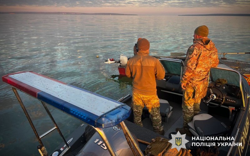 Дівоє чоловіків у формі стоять на катері спиною до камери