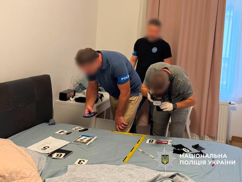 Троє правоохоронців документують вилучення речових доказів, які розкладені на сірій поверхні 
