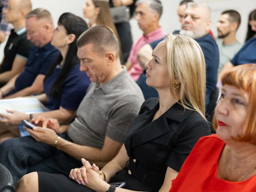 Люди в залі слухають доповідачів