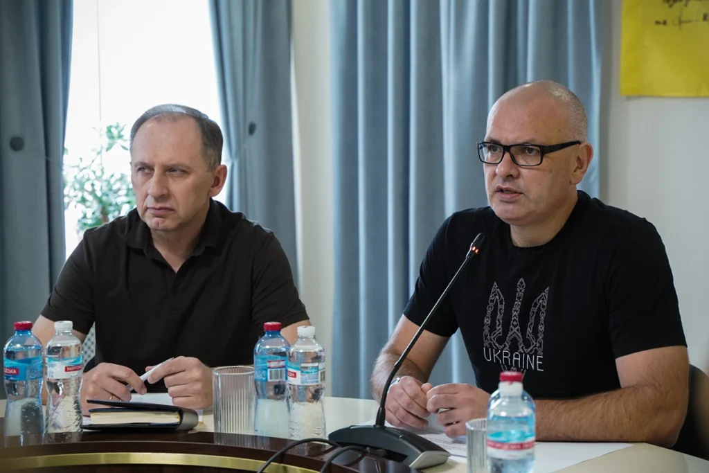 Євген Кончаковський говорить у мікрофон, поруч сидить Мирослав Костенко