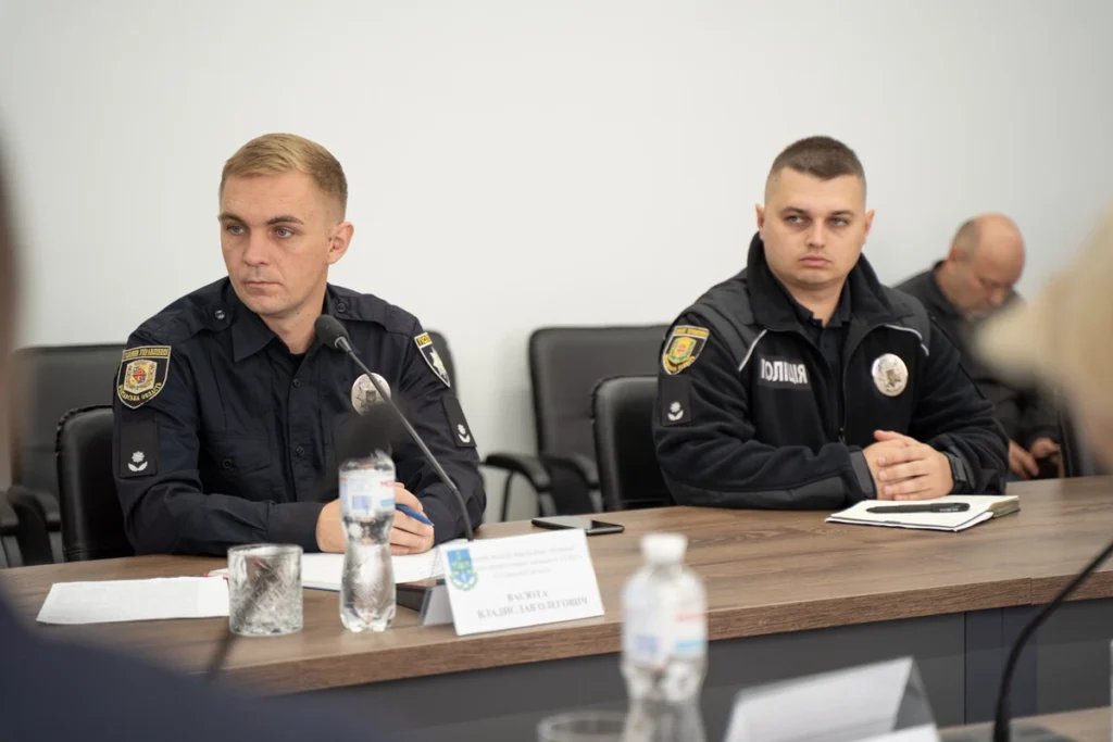 сидять поліцейські за столом на робочій зустрічі та уважно слухають.