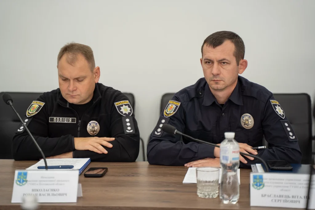 сидять поліцейські за столом на робочій зустрічі та уважно слухають.
