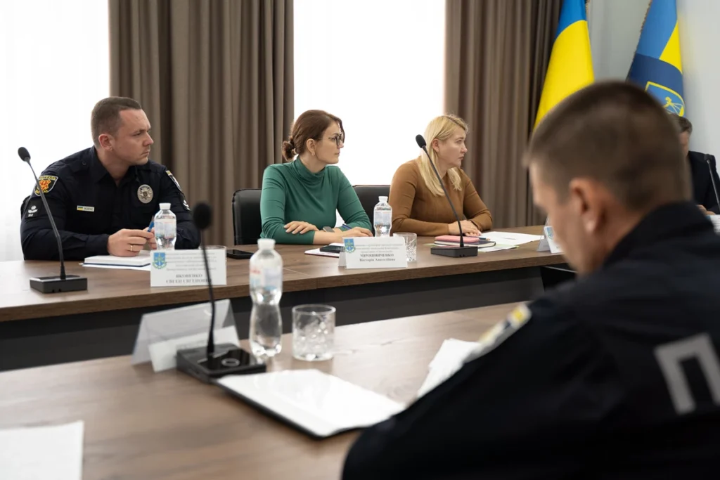 сидять люди за столом на робочій зустрічі та уважно слухають.