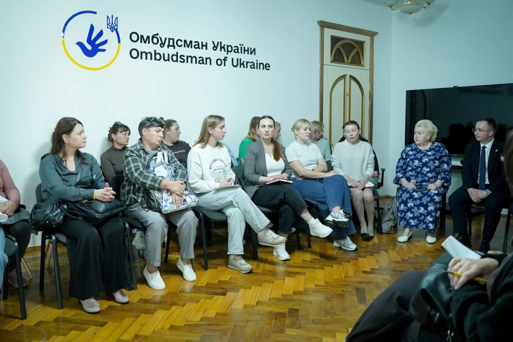 люди сидять на стільцях біля стіни