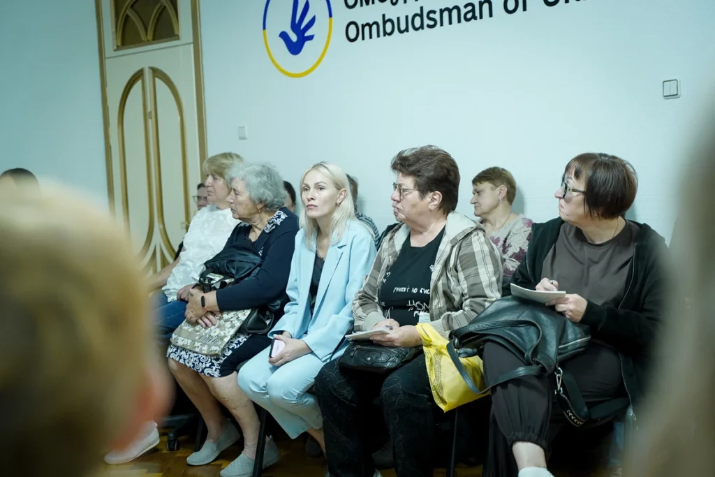 люди сидять на стільцях біля стіни