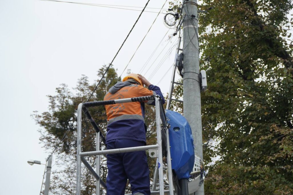 працівник Міськсвітло ремонтує лінію електропередач