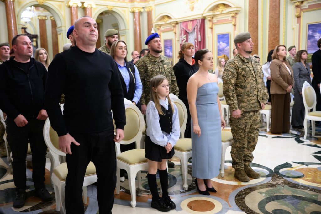 люди в залі урочистостей стоять біля стільців