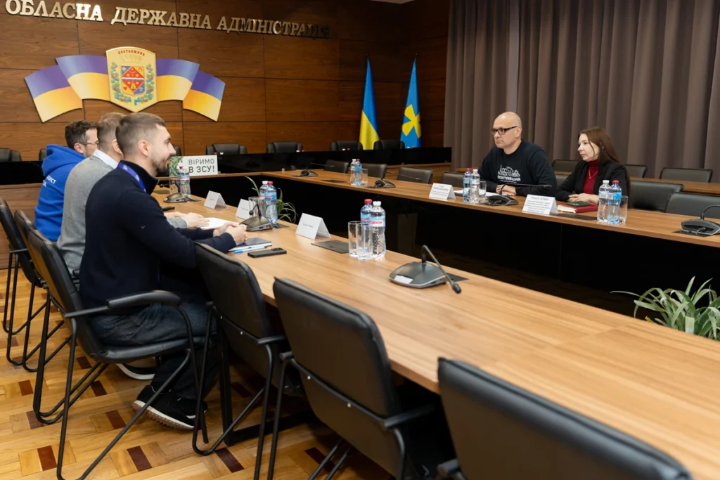учасники зустрічі за столами в залі засідань