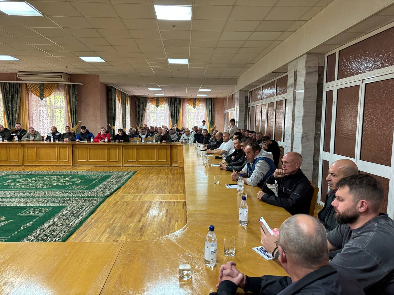 люди за столами в залі засідань