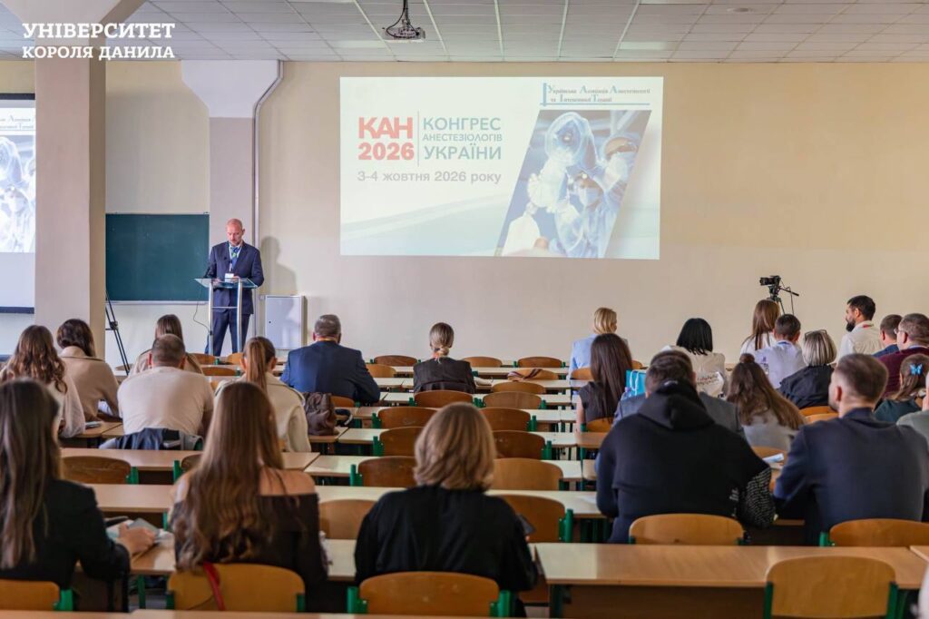 люди в аудиторії, біля екрану виступає спікер