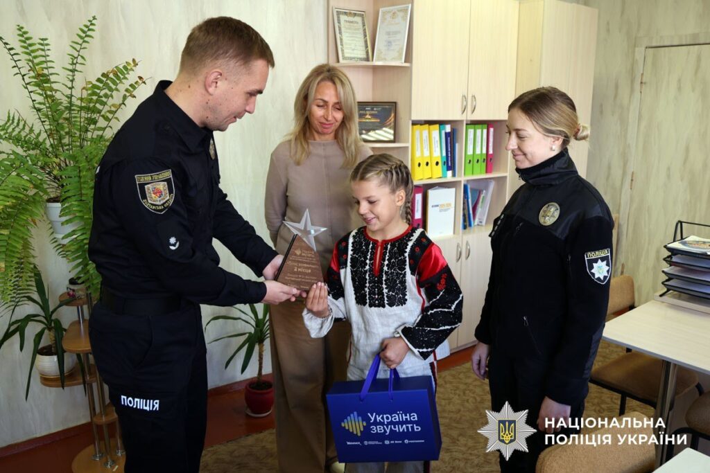 поліцейські вітають дівчину призерку конкурсу