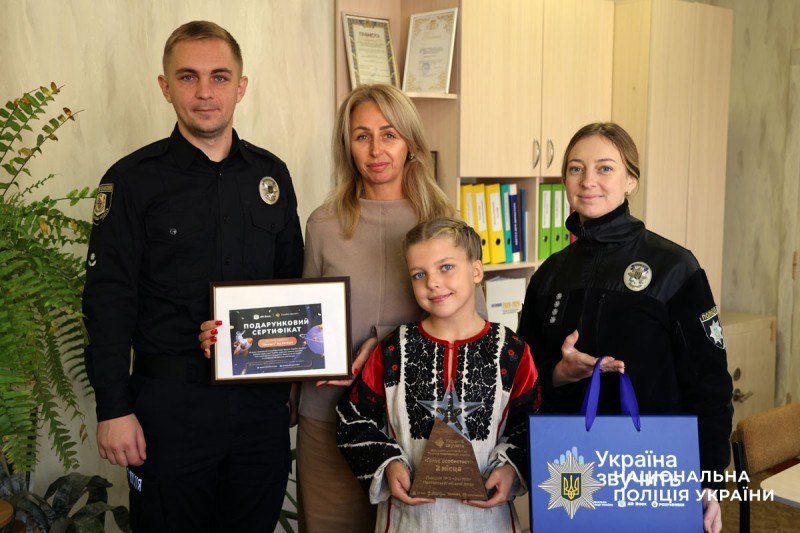 поліцейські вітають дівчину призерку конкурсу