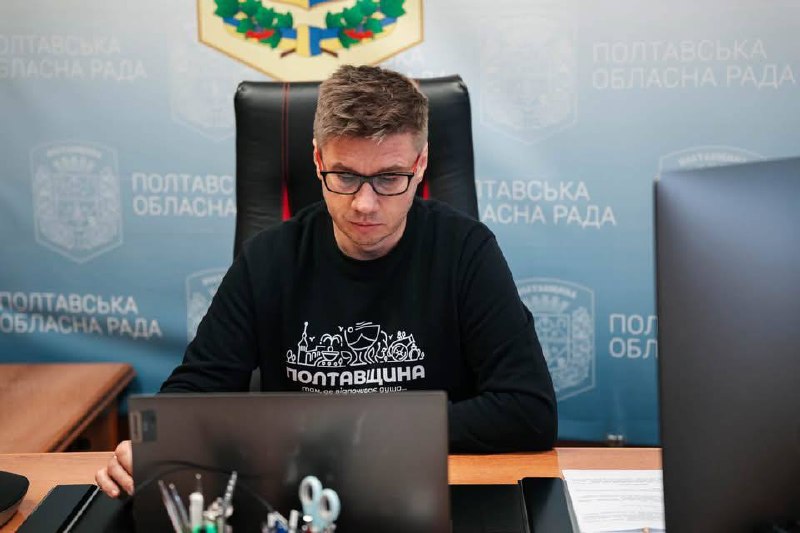 Олександр Біленький за столом із ноутбуком у кабінеті