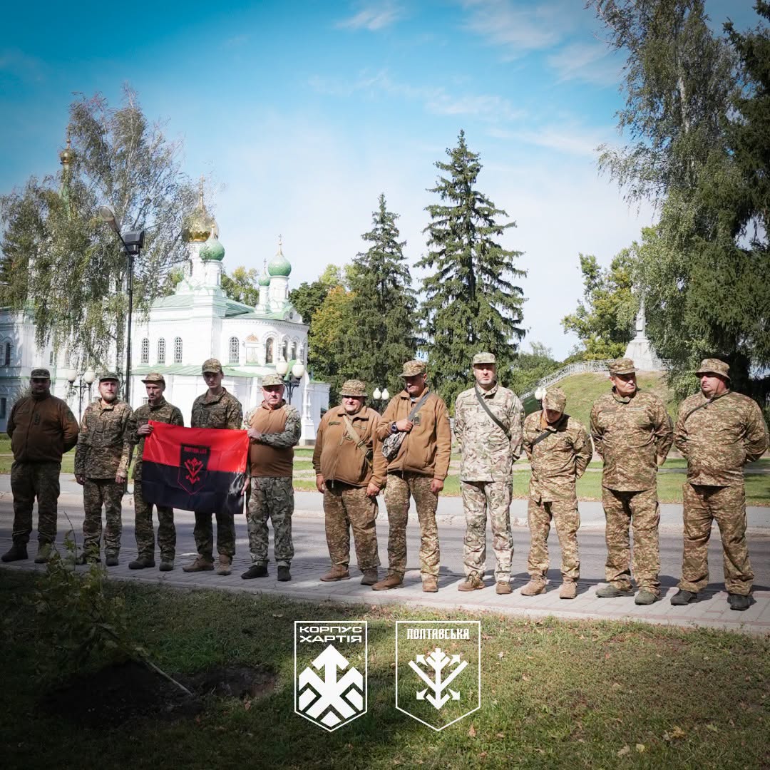 нацгвардійці на тлі Сампсонівської церкви з прапором, перед саджанцем дуба, який лежить в підготовленій для висадки ямці