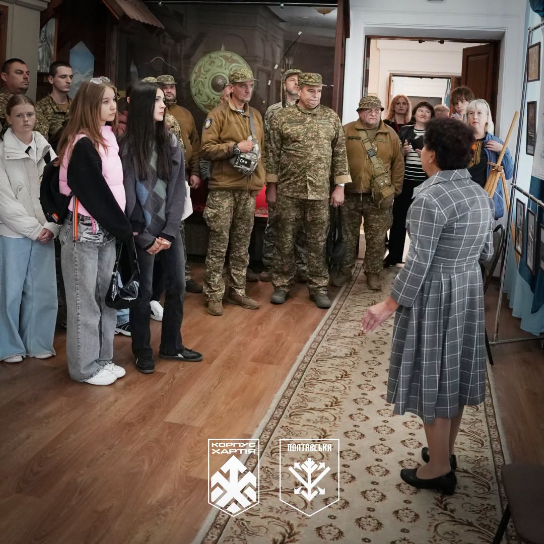 школярі та нацгвардійці в залі музею слухають жінку-екскурсовода