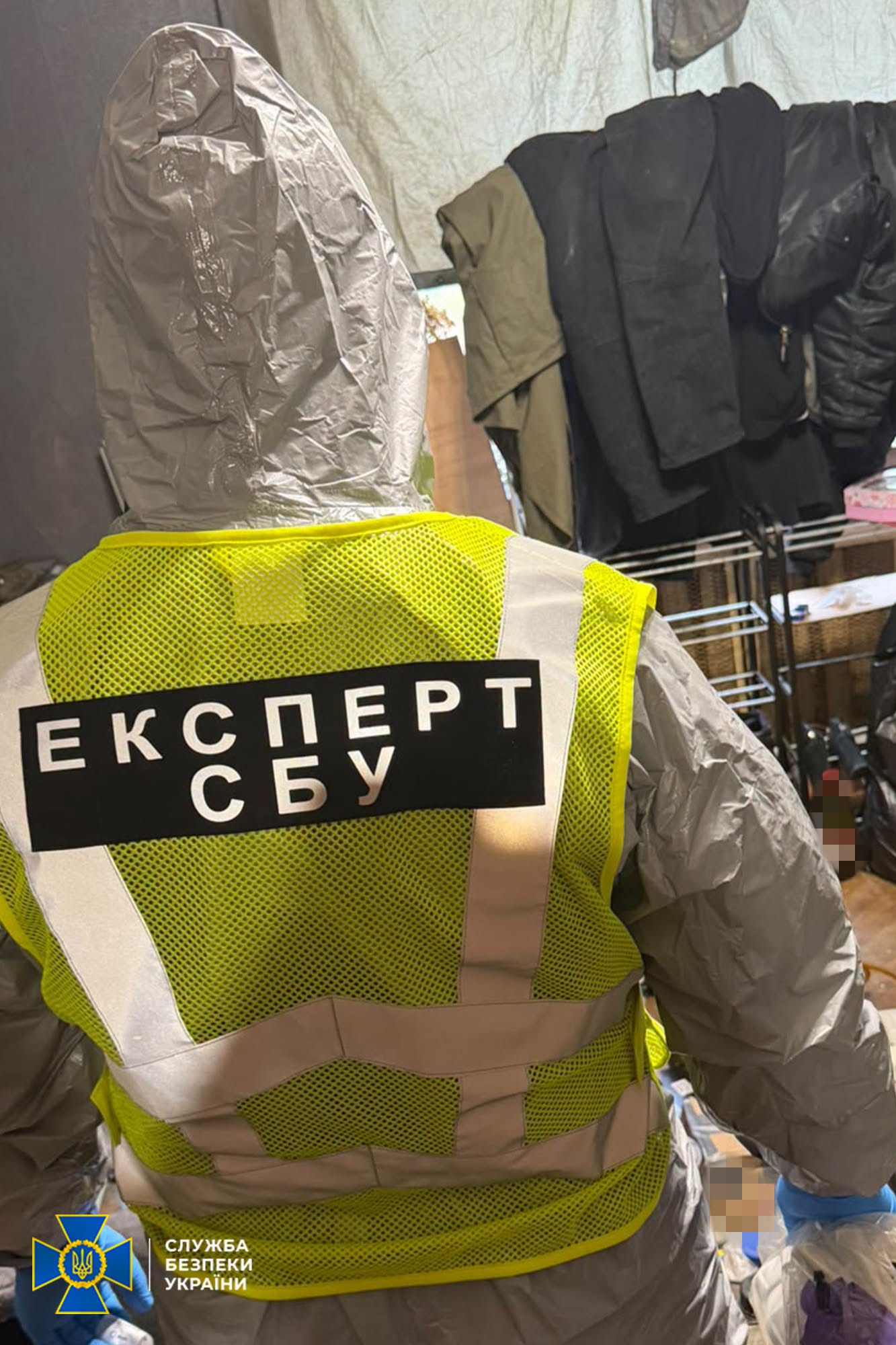 людина в білому спецкостюмі з написом Експерт СБУ