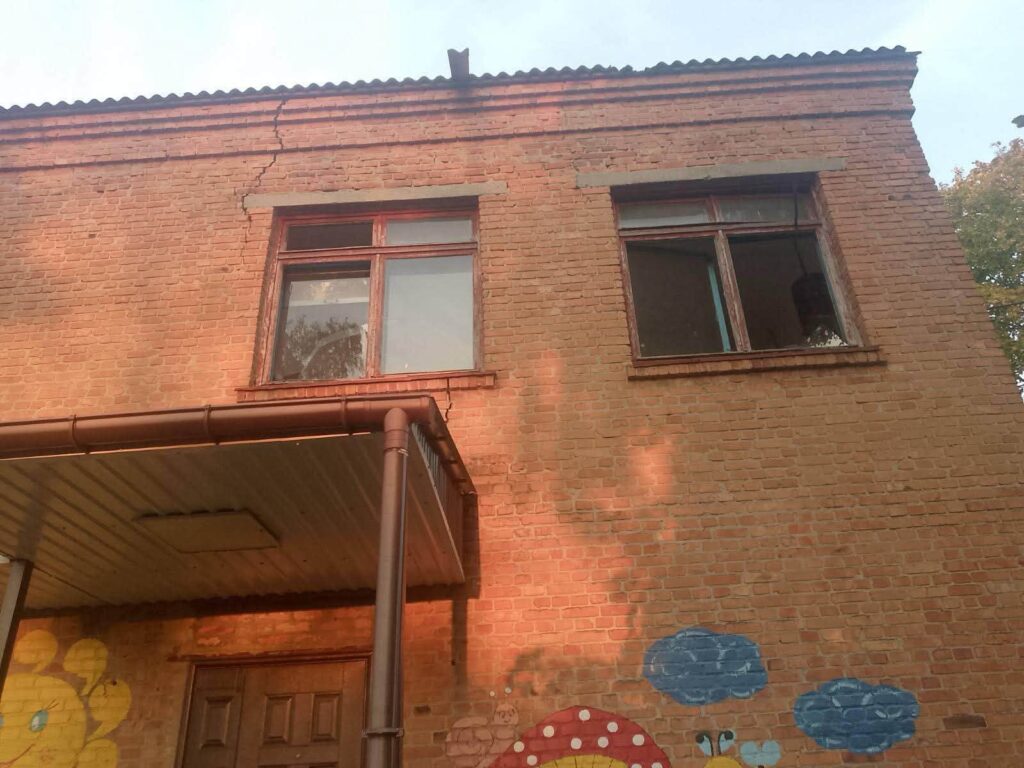 фасад цегляної будівлі з вибитими вікнами
