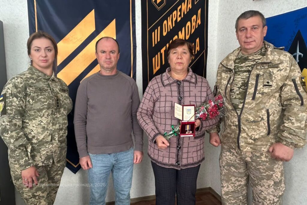 двоє цивільних та двоє військових біля прапорів підрозділів