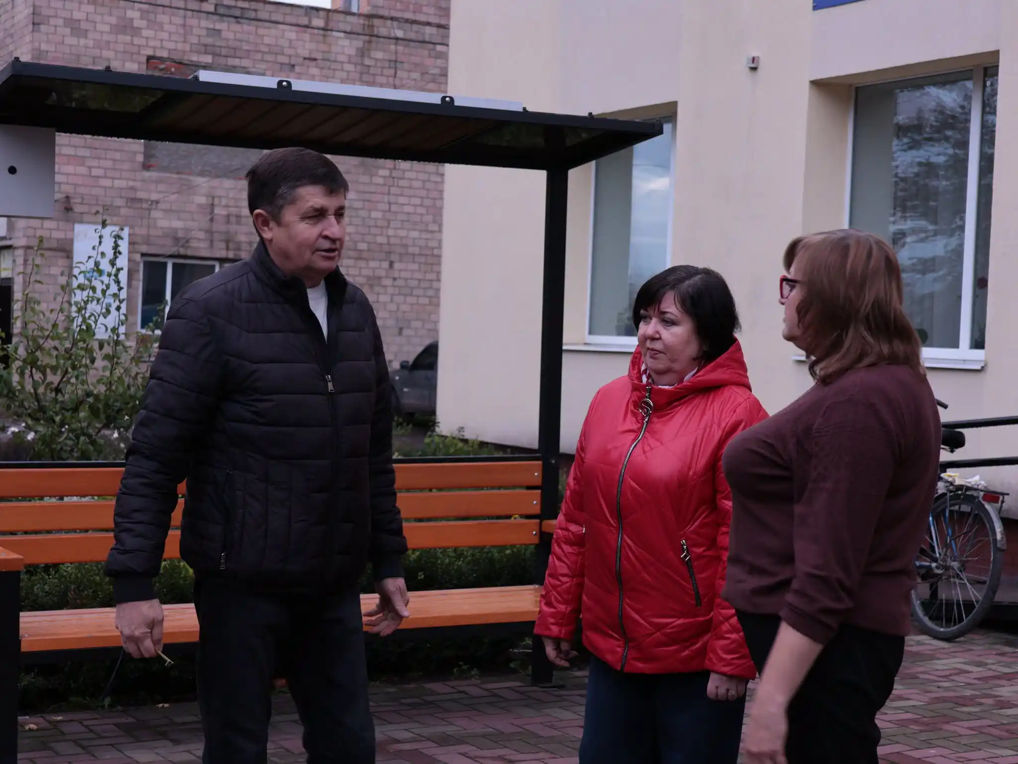 уповноважений розмовляє з двома жінками біля будівлі
